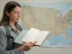 Voyageuse adulte consultant un carnet de vaccination ouvert, avec une carte des États-Unis en arrière-plan dans une illustration médicale sobre et réaliste.
