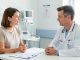 Une patiente adulte échange calmement avec un médecin en oncologie au sujet de l’arrêt du tabac dans une salle de consultation hospitalière lumineuse et rassurante.