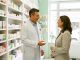 Un pharmacien échange avec une cliente adulte devant un rayon de médicaments sans ordonnance dans une pharmacie française claire et rassurante.