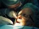 Chirurgien-dentiste réalisant une greffe de gencive sur un patient en cabinet dentaire.